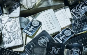 Assorted silver coins, rounds, and bars piled together — guide to buying silver spot price premium and face value
